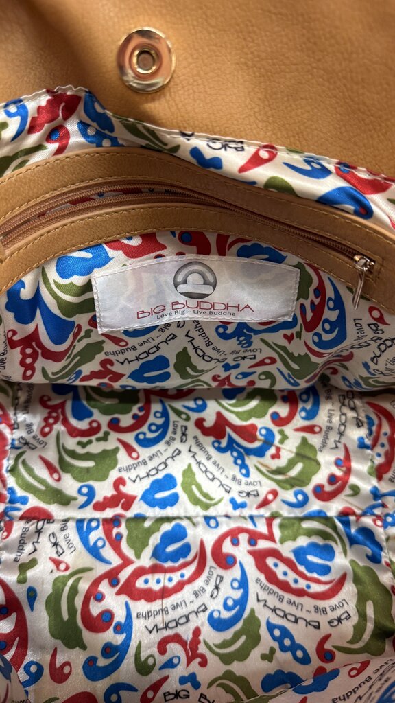 Close-up of a colorful patterned fabric with a brand label on a brown leather background.