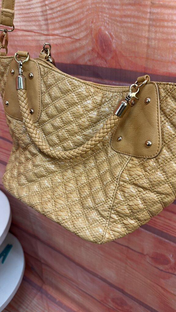 Beige quilted handbag on a wooden surface
