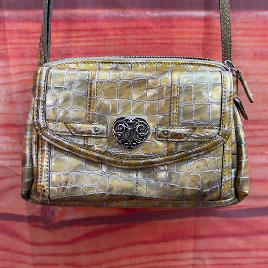 Vintage-style handbag with crocodile pattern on a red and orange striped fabric background