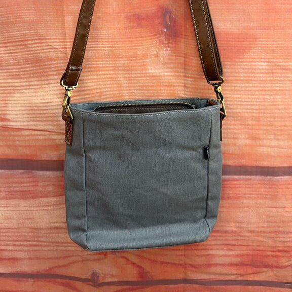 Gray shoulder bag with brown strap on a wooden surface